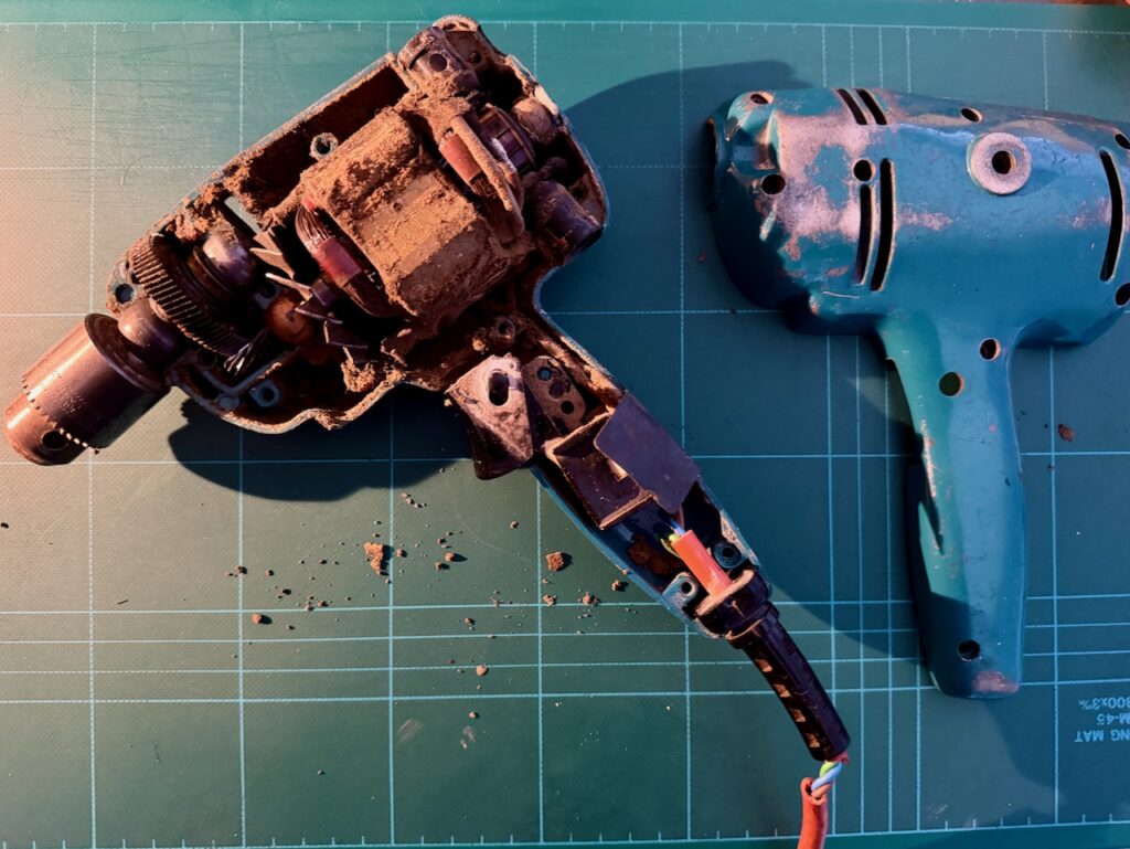 Black and Decker Super D500 drill. Cover removed, revealing inner chambers coated in dust from the materials drilled over the years.