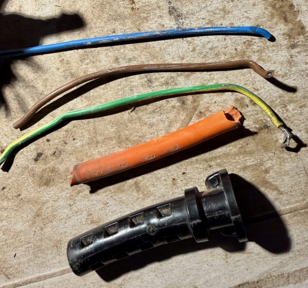 Removing the cable from the strain relief, first by removing the core wires, allowing the outer orange sleeve to be pushed away from its tight fitting to the black outer.