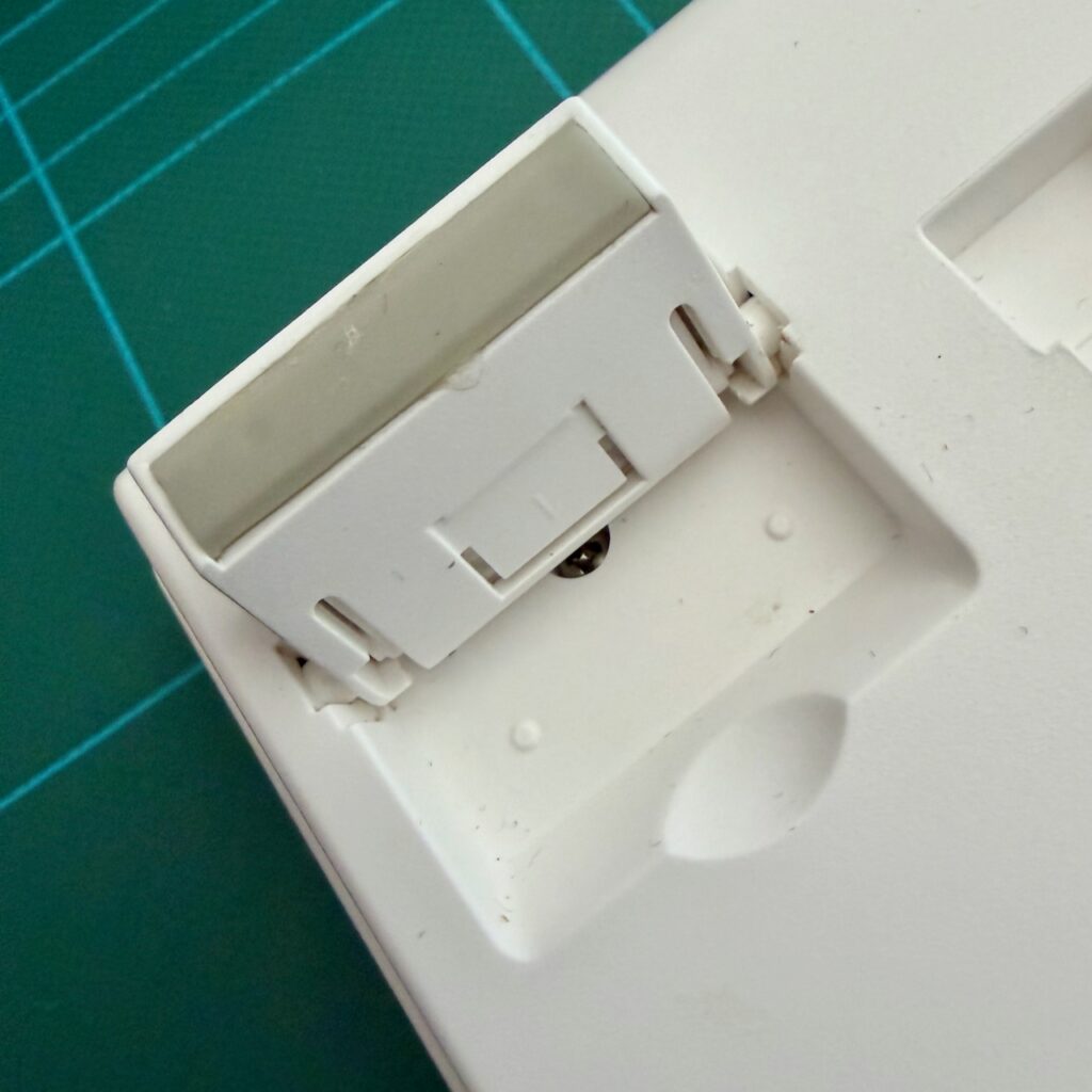 Rear adjustable foot of RK98, behind which is the screw fixing the base to the top cover.